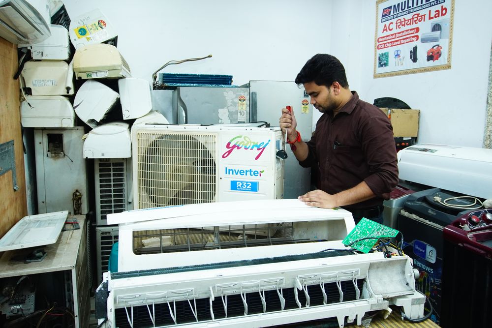 Technician repairing an air conditioner unit
